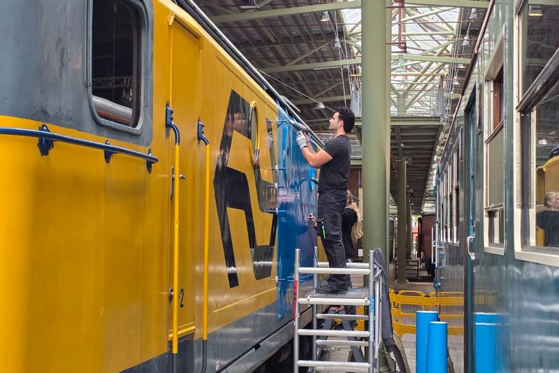 Museumlocomotief 1312 wordt bestickerd in de TCS-huisstijl
